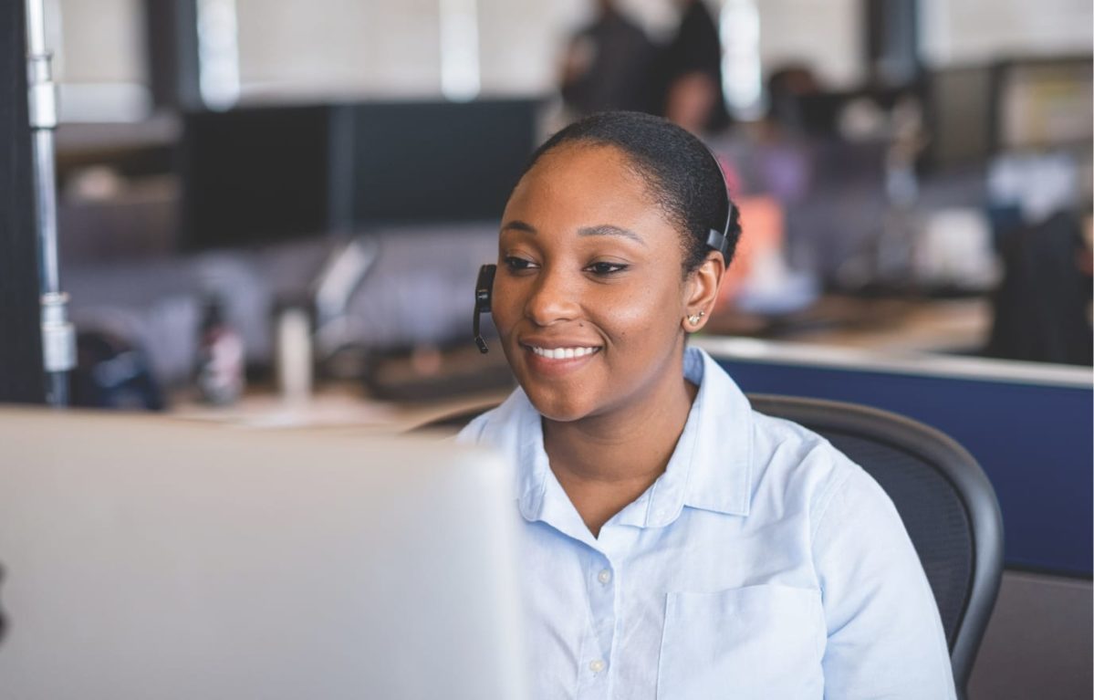 Female support speaking on a headset in front of her computer